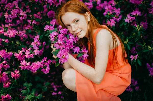 Экспрессивная Девушка Длинными Рыжими Волосами Бледной Кожей Нюхает Цветы Саду — стоковое фото