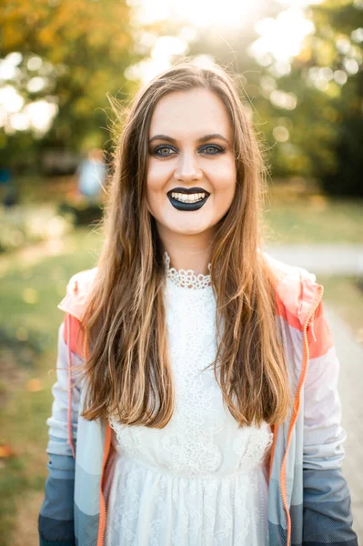 Smiling  girl with gothic make up and surpised face outdoor portrait in sunny park