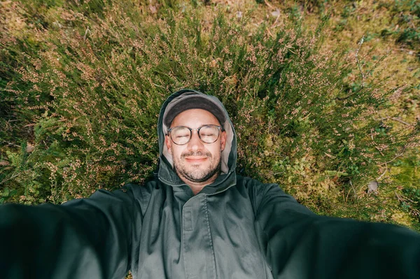 Egy Férfi Erdész Szemüveggel Sapkával Földön Fekszik Erdőben Szelfit Készít — Stock Fotó