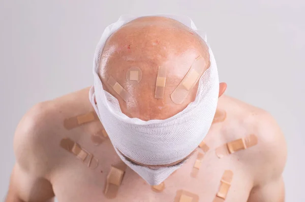 Τραυματίας Άνθρωπος Πολλά Μπαλώματα Στο Σώμα Του Και Δεμένο Κεφάλι — Φωτογραφία Αρχείου