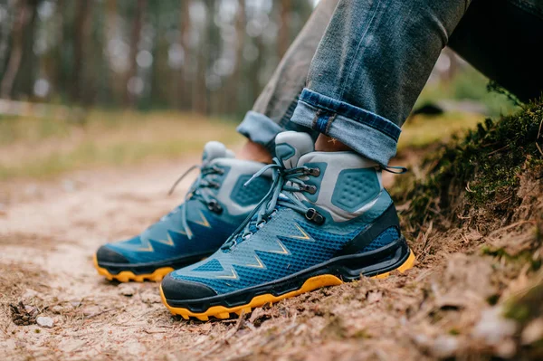 Male legs wearing sportive hiking shoes. Mens legs in trekking boots for outdoor activity.