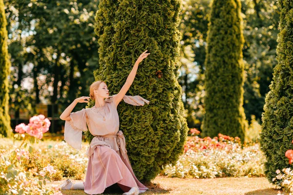若いです優雅な女性バレエダンサーで劇場ドレスポーズで日当たりの良い公園 — ストック写真