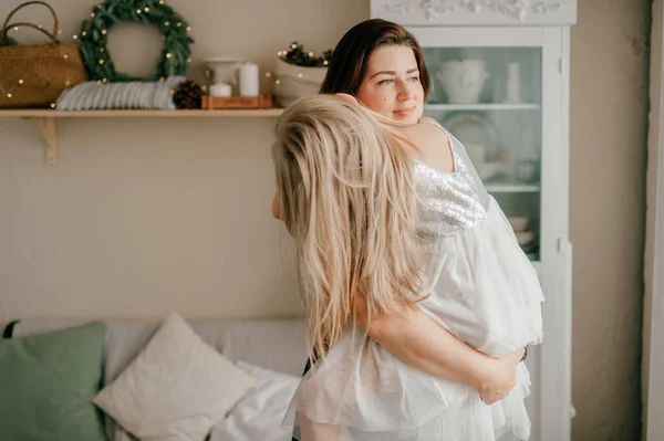 笑顔幸せな女性保持彼女の眠っている娘で彼女の手でシャレースタイルの部屋で新しい年の装飾 — ストック写真