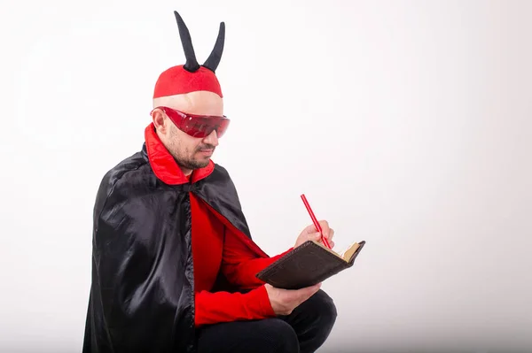 Hombre Caucásico Gafas Sol Rojas Traje Halloween Con Pluma Cuaderno — Foto de Stock