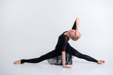 Sırt bükme pozisyonunda jimnastik yapan kadın akrobat, beyaz arka planda güçlü esnek vücut