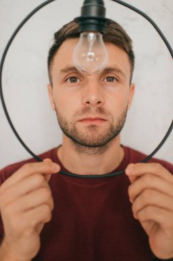 Güzel beyaz erkek üçgen ve daire lambalarına bakıyor.