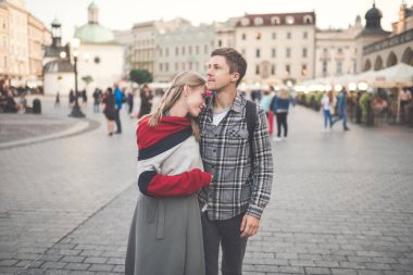 Krakow 'daki merkez meydanında genç ve sevgi dolu bir çift kucaklaşması.)