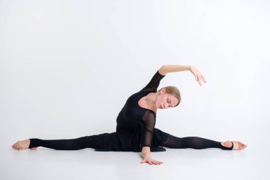 Beyaz stüdyo arka planında akrobatik bir unsurla jimnastik egzersizi. Ritmik jimnastik konsepti. Kafkas modeli tam yükseklikte