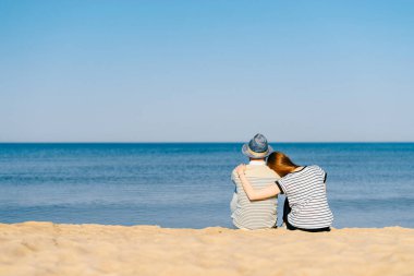 Bir çift aşık kumsalda oturup okyanus ufkuna bakıyorlar. Denizde kucaklaşan kızla birlikte bir oğlan. Tatilde seyahat etmek. Bir çift arkadaş Sonsuz güzel deniz manzarasının tadını çıkarıyor