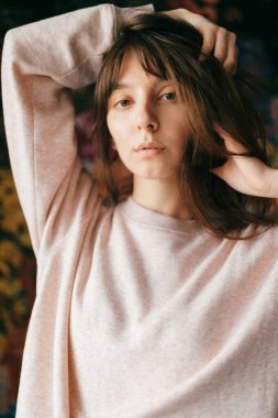 Kameraya poz veren güzel esmer bir kızın kapalı mekan hayat tarzı portresi..