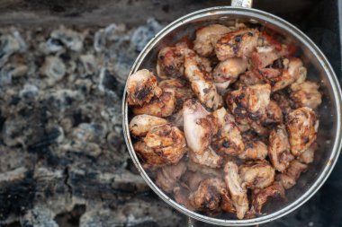 Büyük bir tavadaki çivili kebapların resmi kışın soyu tükenmiş bir brazier 'da bulunur.