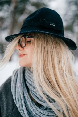 Şapkalı ve gözlüklü güzel sarışın kızın portresi.