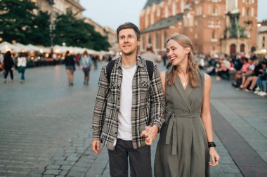 Krakow 'daki merkez meydanında genç ve sevgi dolu bir çift kucaklaşması.)