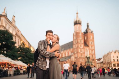 Krakow 'daki merkez meydanında genç ve sevgi dolu bir çift kucaklaşması.)