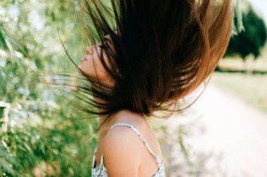 Kafkasyalı genç bir model uzun saçlarını havaya savuruyor. Yaz parkında dans eden sevimli gençler. Doğaya kafa sallayan güzel bir kızın alışılmadık garip yaşam tarzı portresi. Eksantrik yabancı kişi.