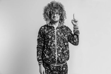 80 'li yaşlarda bir adamın siyah beyaz portresi, gözlüklü ve saç stili kameraya bakıyor ve el ele tutuşuyor. Pozitif yüzlü bir erkek, beyaz arka planda el ele fikir jesti sergiliyor..