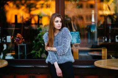 Marketin önünde sabahları soyut yansımalarla kameraya poz veren duygusal düşünceli genç ve güzel bir manken kız. İnanılmaz genç bayan mavi gözlü ruh hali portresi