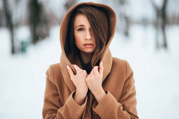 冬季公园里穿着棕色夹克的漂亮的长发金发姑娘的肖像 — 图库照片