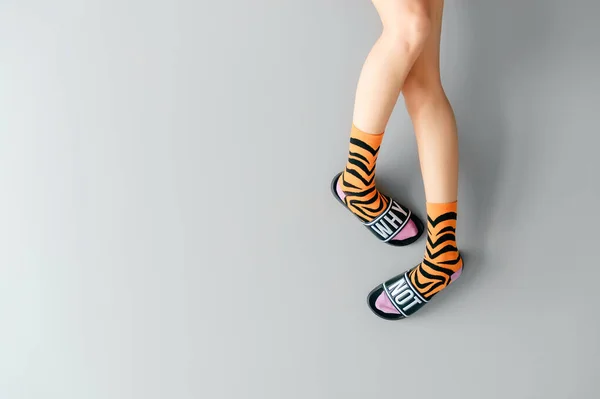 Красивые Женские Ноги Полосатых Оранжевых Носках Модных Резиновых Тапочках Надписью — стоковое фото