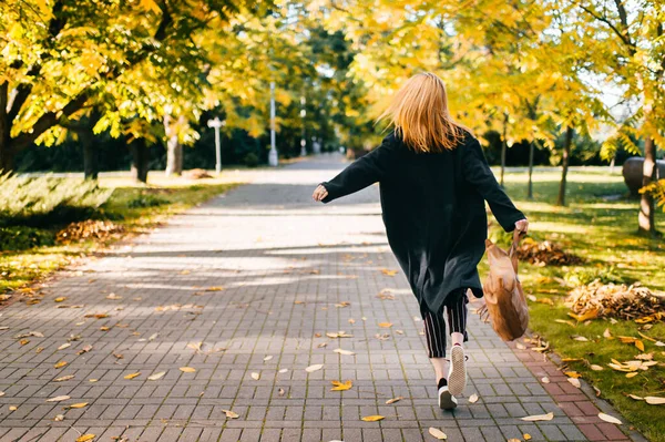Милая Молодая Девушка Черном Пальто Полосатых Штанах Бегает Дороге Осеннем — стоковое фото