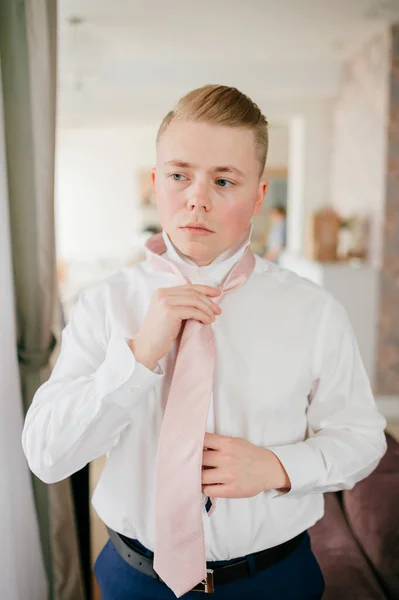 若い新郎は準備が整いました 家での激しい朝 新郎彼のネクタイを固定する — ストック写真