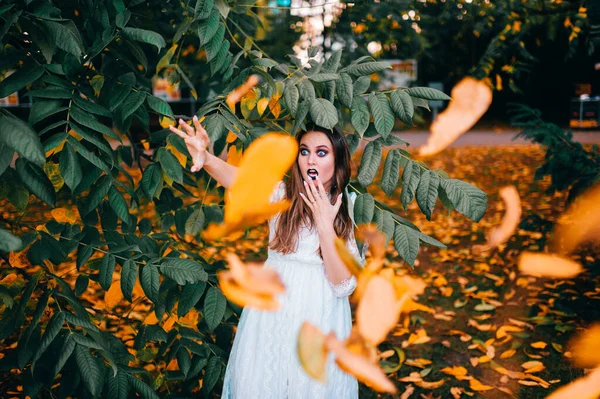 Beautiful girl with gothic make up and funny face expression posing in summer park