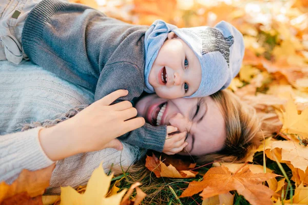 Mãe Feliz Com Seu Bebê Adorável Deitado Folhas Outono Livre — Fotografia de Stock