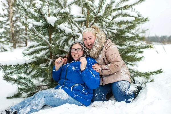雪の冬の屋外で子供のように遊んでいる2人の大人の女性 — ストック写真