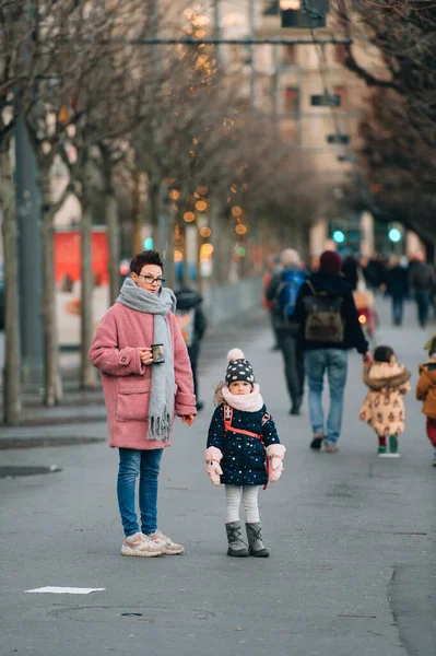 彼女の陽気な娘と若い美しい白人のお母さんの写真は 秋または春に遊歩道を散歩に行きます — ストック写真