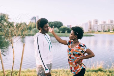 Açık havada ilişki hakkında konuşan koyu tenli bir çift.