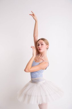Beyaz saçlı, uzun saçlı, gri mayolu ve bale için beyaz etekli güzel bir kız.