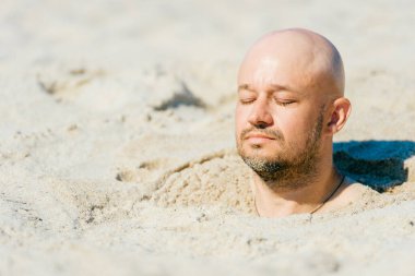 Kum üzerinde kel bir erkek. Çölde canlı canlı gömülen adam. Issız plajlarda acı çeken cezalandırılmış bir çocuk. Okyanus kıyısında cesetle birlikte güneş banyosu yapan komik adamın yakın plan portresi. Terapi.