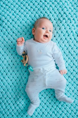 Mavi gözlü, sevimli, yeni doğmuş erkek bebek. İçeriden çekilmiş bir portresi var. Beyaz pijamayla turkuaz yün ekose üzerinde tombul yanaklı şirin bir çocuk. Komik hemşire çocuk duyguları..