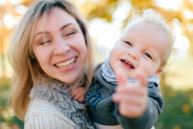 Komik çocuğuyla gülümseyen genç bir kadın. Doğada yakın plan bir portre.