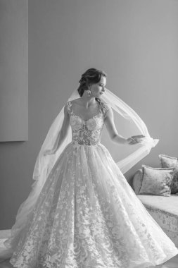 Gelinlik giymiş güzel gelinin siyah beyaz portresi dokunur ve duvağını otel odasına atar..