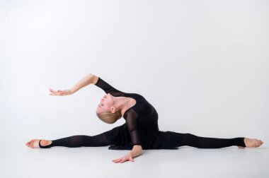 Sanat jimnastiği konsepti. Beyaz model, tam boy. Genç kız sanat jimnastiğiyle meşgul.