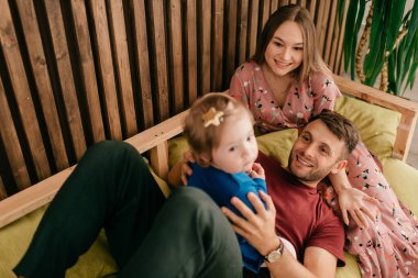 Kafkasyalı anne ve güçlü baba yalan söyleyip sevimli küçük kızlarıyla oynuyorlar.