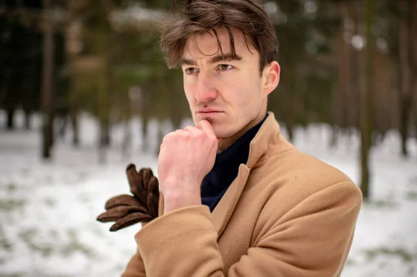 雪に覆われた森の中でポーズを取るスタイリッシュな正式な服のエレガントな自信を持った男 男性とハンサムな男性でビジネススタイルの服屋外肖像画 — ストック写真