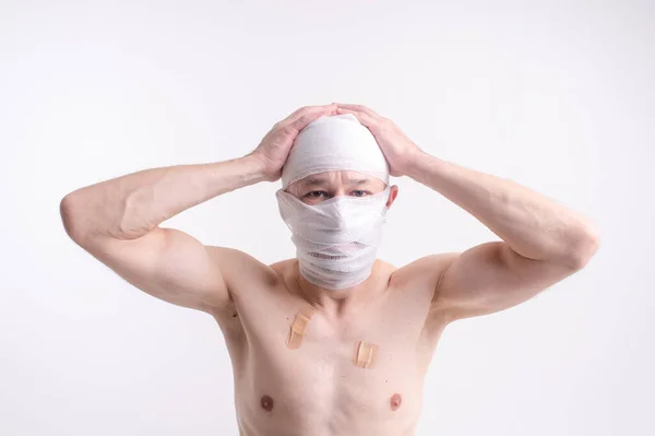 Injured Man Many Patches His Body Bandaged Head Isolated White — Stock Photo, Image