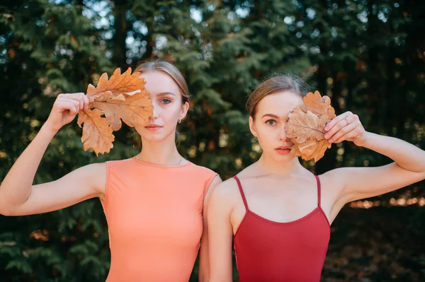 Dos Chicas Jóvenes Pie Aire Libre Con Hojas Sus Manos —  Fotos de Stock