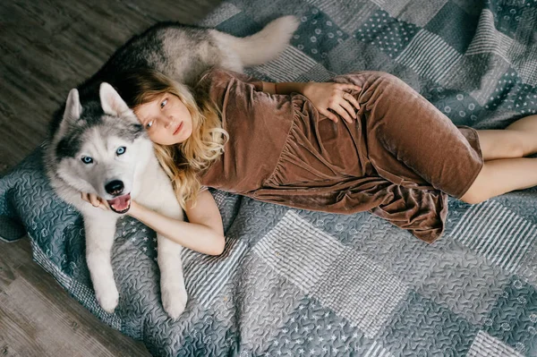 Mladá Dívka Hnědých Šatech Ležící Doma Posteli Spící Husky Štěně — Stock fotografie