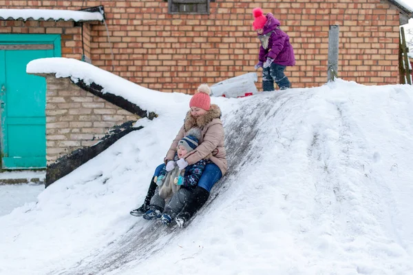 母亲和儿子在冬天骑马滑行 快乐的家庭在冬天过得很开心 俄罗斯传统的冬季娱乐活动 — 图库照片