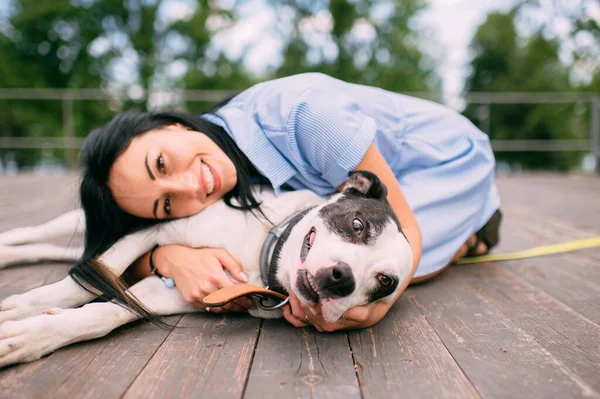 ハンサムな若いです白人の女の子の写真はかなり犬とこの瞬間の喜びと木製の床にあります — ストック写真