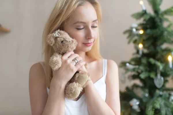 Fiatal Lány Hálóing Ölelés Játék Medve Karácsonyfa Háttérben — Stock Fotó