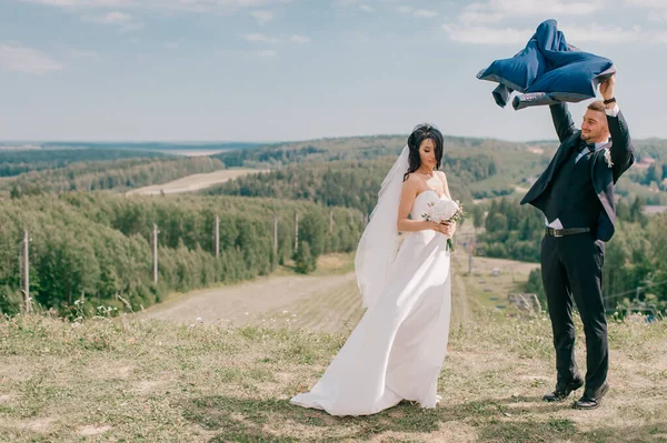 Жених Курткой Руках Прячет Невесту Солнца — стоковое фото