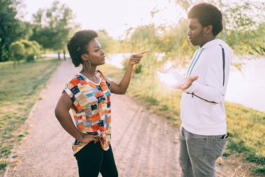 Açık havada ilişki hakkında konuşan koyu tenli bir çift.