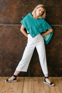 Stüdyoda poz veren şık elbiseli güzel sarışın manken.