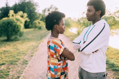 Açık havada ilişki hakkında konuşan koyu tenli bir çift.