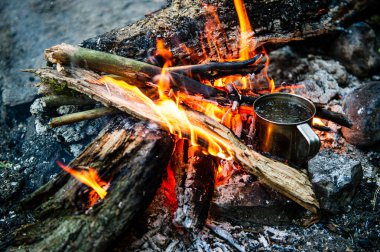 Çayı metal bardakta yakın, şenlik ateşinde ısınır.