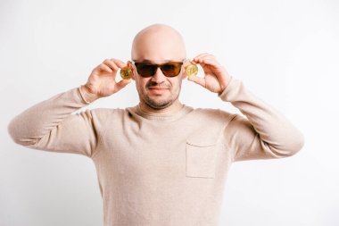 Bitcoin paraları elinde tutan mutlu kel iş adamı. Çılgın, alışılmadık yetişkin adam sanal para sevdalısı. Başarılı finans tüccarı etkileyici yüz. Beyaz üzerine izole edilmiş komik kripto madenci portresi